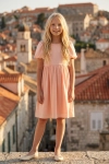 Feestjurk Sia in roze – volledige look van voren met de oude stad als achtergrond